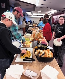 Students getting food during Thanksgiving Potluck